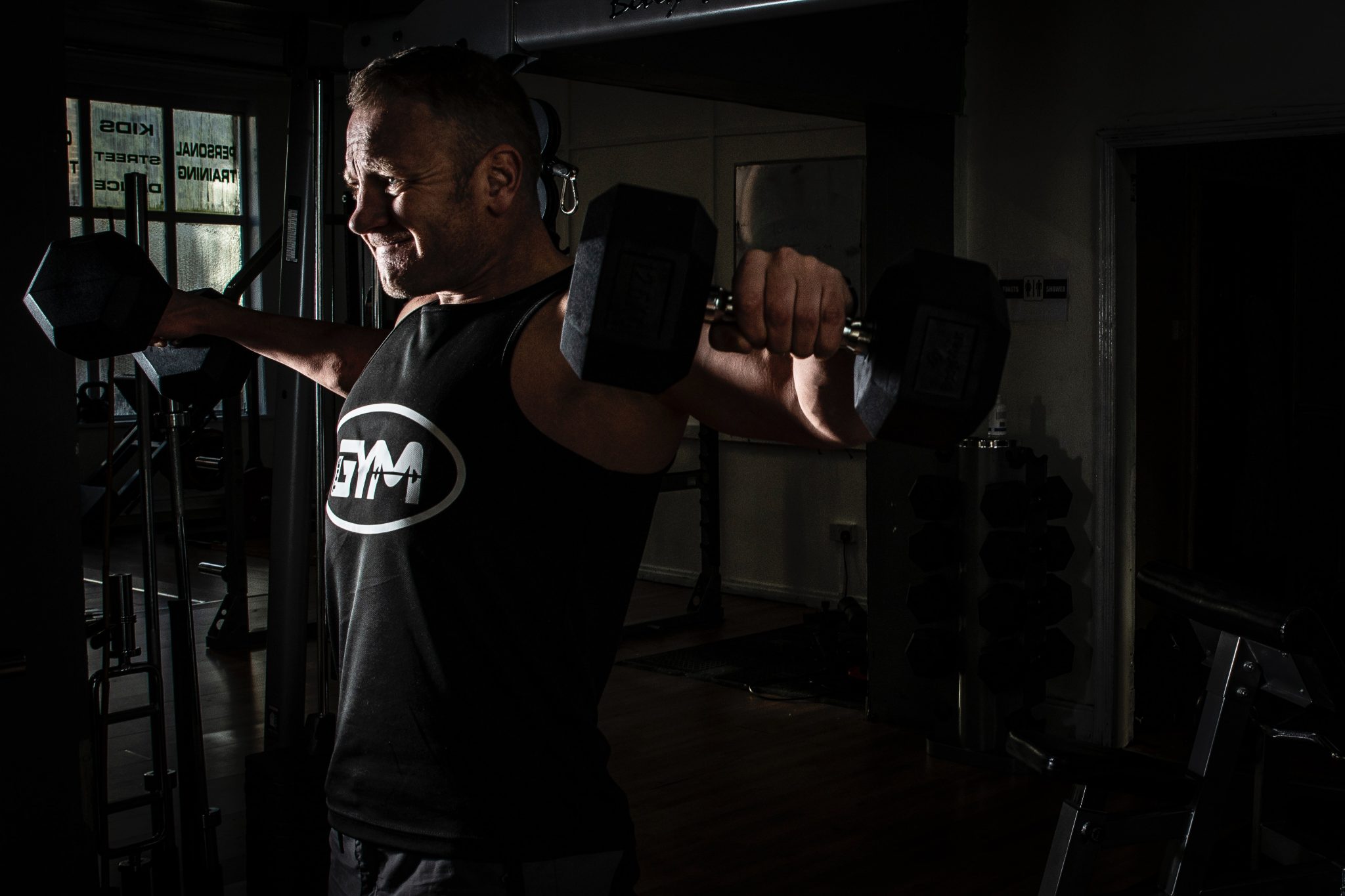 man lifting dumbbells