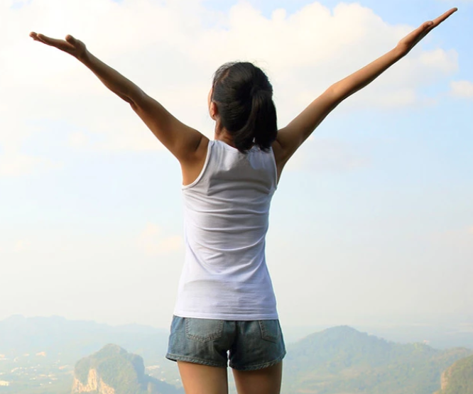 happy woman on top of the mountain