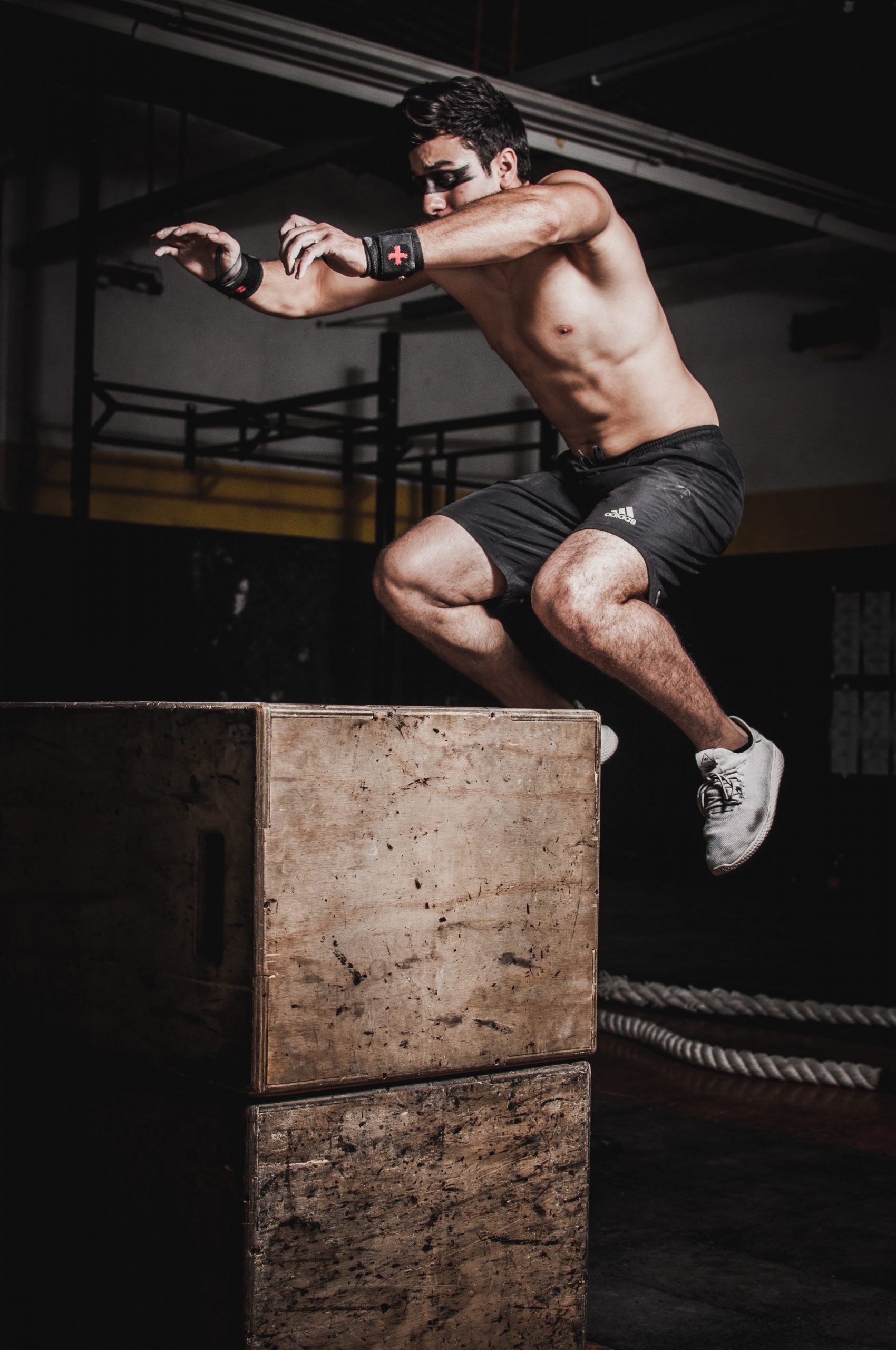 man jumping on a stack boxes workout gym